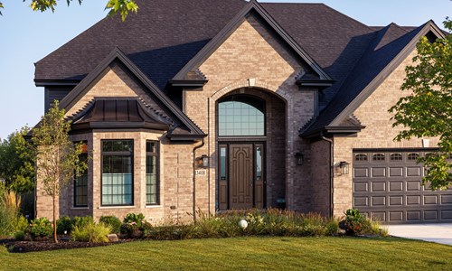 tan custom brick home with black accents