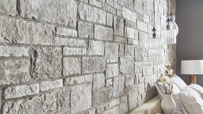 Cultured Stone Sculpted Ashlar Silver Shore gray thin stone on interior wall of bedroom
