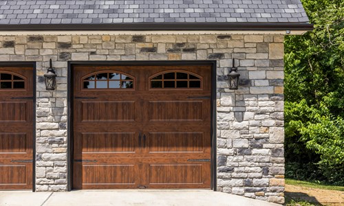 Glen-Gery | Limestone Kentucky Gray building stone veneer on exterior of home garage with wooden garage doors and coach light