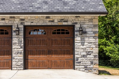 Glen-Gery | Limestone Kentucky Gray building stone veneer on exterior of home garage with wooden garage doors and coach light