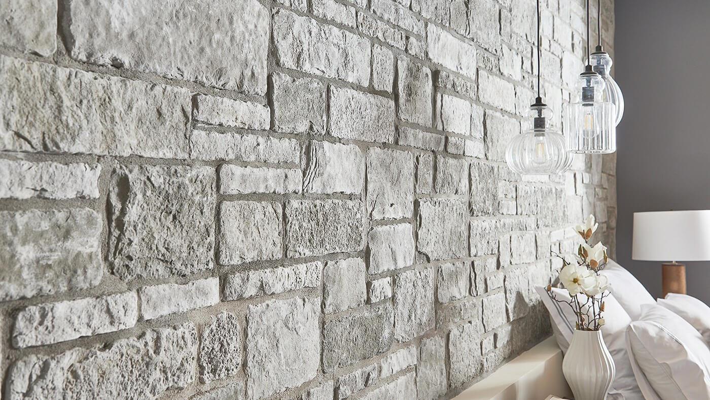 Cultured Stone Sculpted Ashlar Silver Shore gray thin stone on interior wall of bedroom
