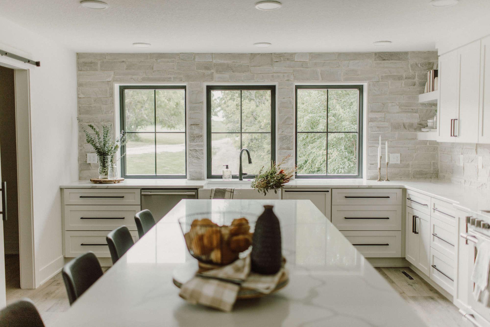 Cultured Stone Country Ledgestone Wheaton thin stone as backsplash in white kitchen with black trimmed windows